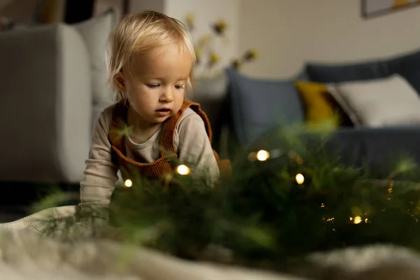 Portrait de style de vie de bébé caucasien mignon d'un an jouant avec des boules sur le sol à la maison. Joyeux Noël et bonne année 2022 — Photo