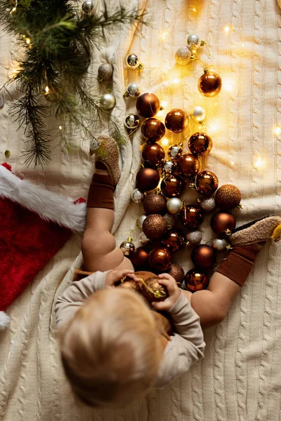Portrait de style de vie de bébé caucasien mignon d'un an jouant avec des boules sur le sol à la maison. Joyeux Noël et bonne année 2022 — Photo
