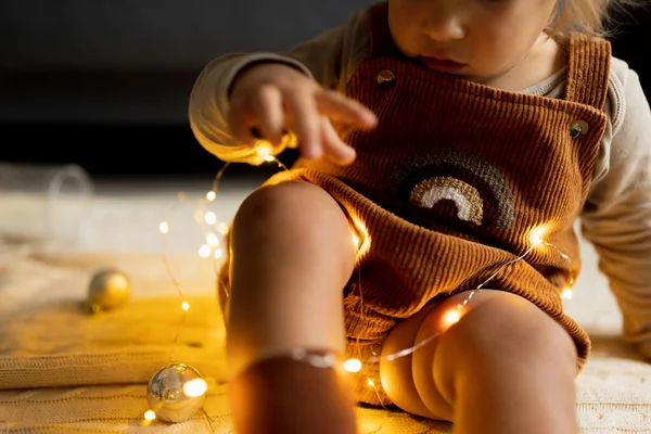 Portrait de style de vie de bébé caucasien mignon d'un an jouant avec des boules sur le sol à la maison. Joyeux Noël et bonne année 2022 — Photo