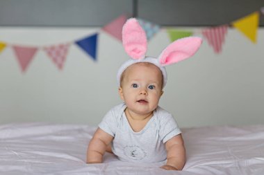 Kafkasyalı mutlu bir bebek. Altı aylık. Tavşan kulaklı, bantlı.