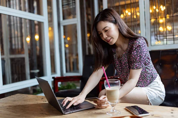 Bastante joven asiático negocios mujer usando laptop en moderno café. — Foto de Stock