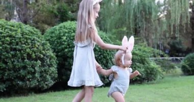 Tavşan Kulaklı İki Çocuk Bahçede ya da Parkta Paskalya Yumurtası Avı 'nı boyarken. Beyaz tatlı bir bebek ve kız kardeşi arka bahçede birlikte vakit geçiriyorlar. Yavaş çekim