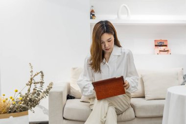 Küçük bir iş kurun, akıllı telefon ya da tablet kullanan Çinli genç girişimci paket ürün kutusu hazırlamak için online alışveriş siparişlerini alıp kontrol edin. çevrimiçi satış kavramı