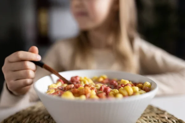 Küçük şirin beyaz kız sabahın erken saatlerinde mutfakta oturmuş renkli mısır gevreği ve sütle kahvaltı hazırlıyor. Sağlıklı yiyeceklerle, sağlıklı yaşam tarzıyla hayatın tadını çıkaran bir çocuk. Telifsiz Stok Imajlar