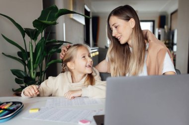 Beyaz bir aile evde çalışır ve bilgisayar kullanarak ders çalışır. Çocuk için uzaklık ya da uzaktan öğrenme. Coronavirus covid-19 karantinası sırasında ödev matematiği okuyan oldukça şık bir kız öğrenci.