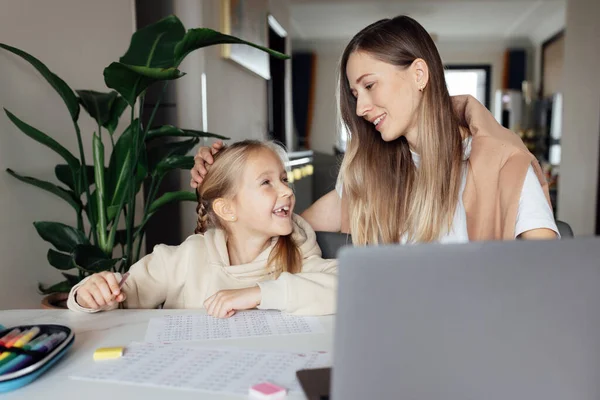 Beyaz bir aile evde çalışır ve bilgisayar kullanarak ders çalışır. Çocuk için uzaklık ya da uzaktan öğrenme. Coronavirus covid-19 karantinası sırasında ödev matematiği okuyan oldukça şık bir kız öğrenci.