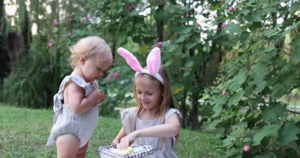 Twee Kinderen Dragen Konijnenoren Wanneer Pick Geschilderd Paaseieren Jacht Tuin — Stockvideo