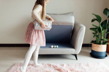 Kafkasyalı küçük kız sekiz yaşında evde, renkli paskalya yumurtalarıyla oturuyor. Coronavirus covid-19 salgını sırasında evde kal.