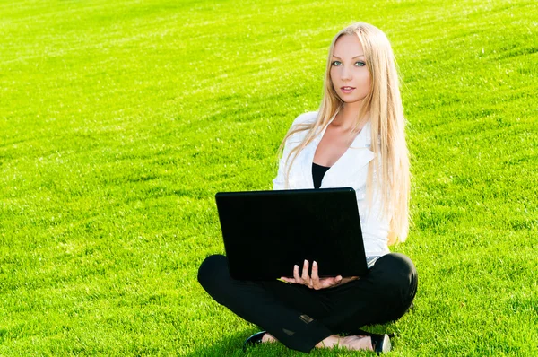 Business woman sitting on the grass — Stock Photo, Image