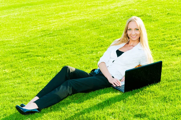 Business woman lies on the grass — Stock Photo, Image