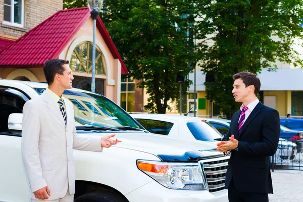 Dos hombres de negocios hablando de coches Imagen de archivo