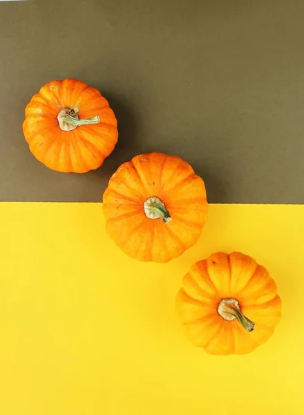 Three Orange Pumpkins Yellow Brown Background Top View Autumn Harvest — Stock Photo, Image