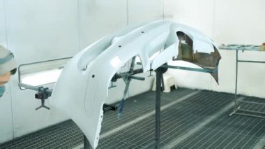 Araba servisi sprey kutuya otomatik beyaz tampon boyuyor.