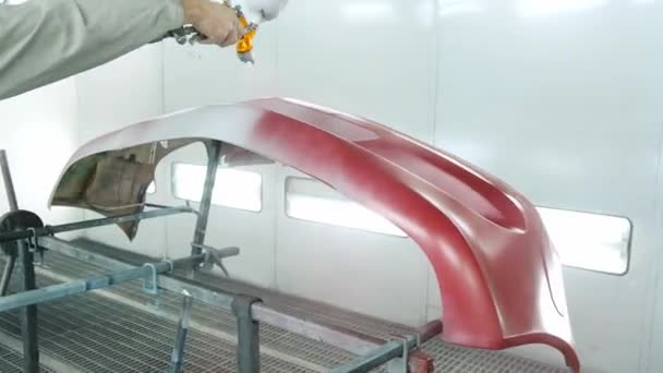 자동차 서비스업자는 진열대에서 흰색 자동차 범퍼를 붉게칠 한다 — 비디오