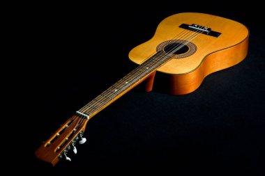 Siyah zemin üzerinde titreşimli dizeleri olan klasik gitar