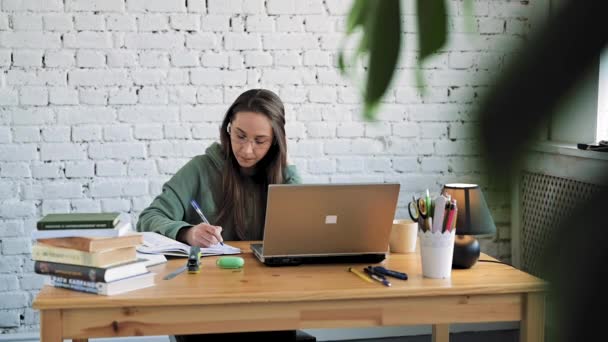 Estudante de menina branca grave em óculos digitando no laptop preparando o trabalho do curso — Vídeo de Stock