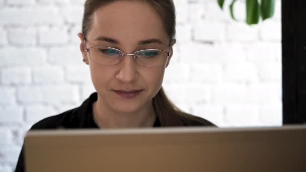 Woman In Glasses Looking on The Monitor e Internet Surf. A tela do monitor é refletida nos óculos. Fecha. Trabalho no Home Office. Trabalho remoto — Vídeo de Stock