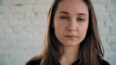 Kız kafasını kaldırıyor, güzel yeşil gözleri açıyor ve gülümsüyor. Yakın plan. Yavaş çekim