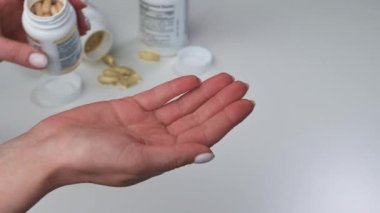 spor, sağlıklı yaşam tarzı, ilaç, beslenme takviyeleri ve insan konsepti - kadın haplarına yakın çekim balık yağı, kavanozdan ele omega-3