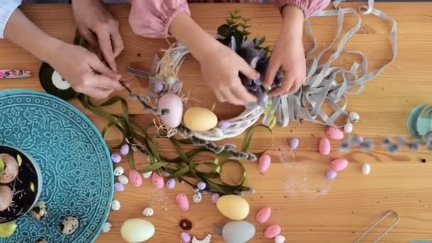 Mãos de mãe e bebê menina fazendo decoração de Páscoa. Close-up. Vista de cima. — Vídeo de Stock