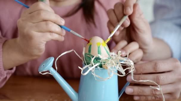 Szczęśliwa dziewczynka ładny zabawy podczas malowania jaj na Wielkanoc w czasie wiosny w domu. Dziecko malujące jajka. Szczęśliwa rodzina przygotowuje się do Wielkanocy, ciesząc DIY dekoracji w domu. Zbliżenie. 4K — Wideo stockowe