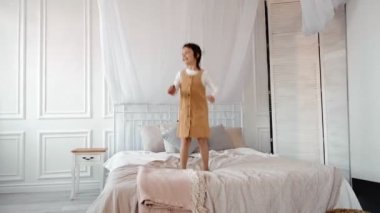 Komik, sevimli, mutlu, esmer kız yatağa atlıyor, küçük tatlı bir çocuk, müzik eşliğinde dans ediyor, yatak odasında tek başına eğleniyor, sabahları şarkıcı taklidi yapıyor.