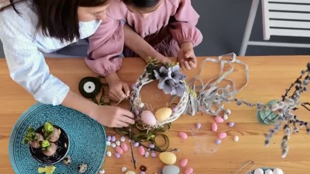 Genç kadın paskalya bayramı masasını tavşan ve yumurta süsleme çelengi ile hazırlıyor. Yakın plan. Yukarıdan görüntüle — Stok video