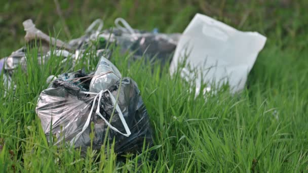 A package of plastic garbage lies in the forest on a forest road, pollution of nature, garbage and nature, the sun, close-up, Slow motion — Stock Video