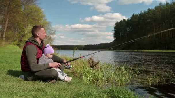 Rodzinne łowienie ryb, tata zachęca swojego małego syna na ryby. — Wideo stockowe