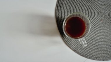Kahve makinesinden ahşap masa arkasındaki beyaz fincana siyah kahve dökülüyor. Taze koyu espresso kahve. Üst Görünüm, Yavaş Çekim