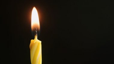 Alevler koyu mum makrosu içinde yanıyor, karanlık arka plana yakın çekim, yavaş çekim 4k