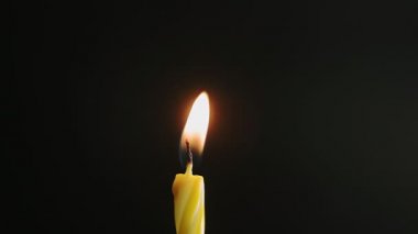 Büyük sarı mum ışıkları ve söndürme, siyah arka planda izole edilmiş, yavaş çekim, merkezi çerçeve kapatma