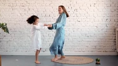 Mutlu aile genç anne bebek bakıcısı oturma odasında dans sevimli küçük çocuk kız ile eğlenmek, çocuk kızı ile kaygısız anne evde birlikte oynarken komik aktivite zevk atlama atlama