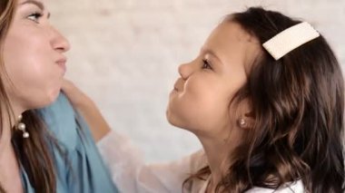 Sevecen, sevimli, evlat edinilmiş bir kız çocuğu koruyucu aileye sarılıyor gözleri kapalı bir anne, sevimli küçük bir kız çocuğu annesine sarılıyor şefkatli bir anın tadını çıkarıyor. Aile aptalı