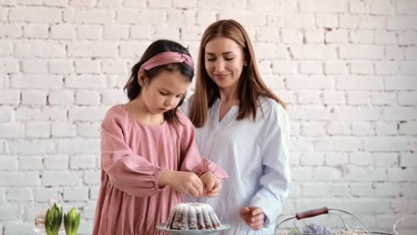 Las manos de las chicas están sentadas en el éster. La boca del festival es Esther Brad Into Pieces. La chica decora a Esther Brad. Decora el pastel con polvo — Vídeo de stock