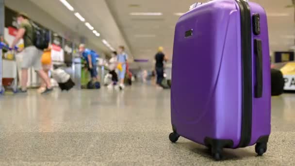 Purple suitcase at the airport on a timelapse background with people, 4k — Vídeos de Stock