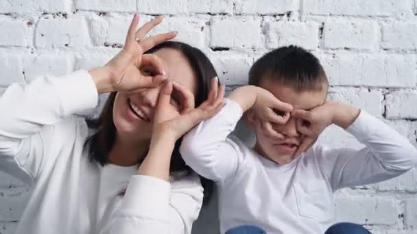 Gelukkig familie liefhebbend jong mam spelen piggybacking schattig, mam en zoon hebben plezier thuis close-up van donker haar, 4K — Stockvideo