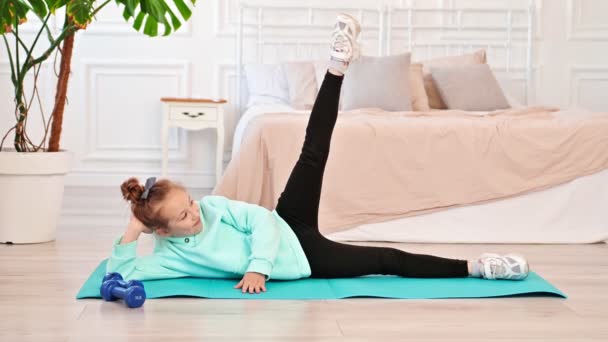 Happy teen girl doing workout at home on sports mat in bedroom. Gymnastics does sports exercises, Slow motion — Video Stock