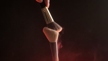 Makyaj fırçası ve renkli toz parçacıkları patlıyor. Yakın plan, hayalet esnek 4K. Yavaş Hareket.