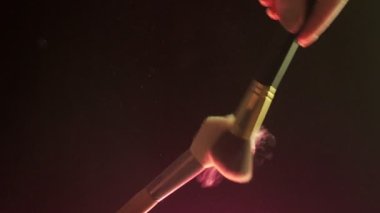 Makyaj fırçaları koyu arka plan ve küçük kozmetik parçacıkları, yavaş çekim birbirine dokunur,