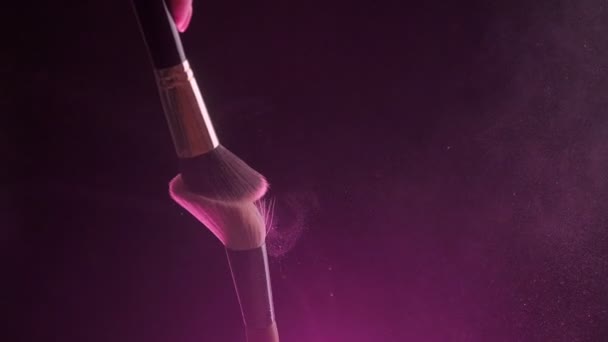 Two Make-up brushes close-up with pink powder on a black background, Slow motion — Wideo stockowe