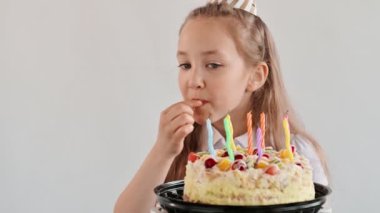 Doğum günün kutlu olsun. Parti zamanı. Komik çocuk pasta yer, yüzünü ve ellerini kirletir. Tatlı kız bir tatil pastasını ısırıyor ve parmaklarını yalıyor. Yavaş çekim