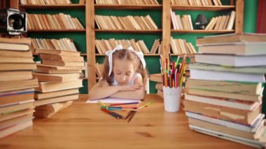 Yorgun genç sarışın bir kızın portresi okuldaki masada bir defterle ders veriyor. Genç liseli kız, yazıt yardımıyla çalışırken bir resim gösteriyor. Yakından bakınca yorgun görünüyorsun.