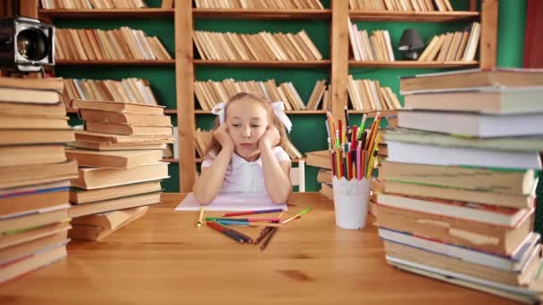Κουρασμένη έφηβη στη βιβλιοθήκη πέφτει από την κούραση στο τραπέζι με τα βιβλία. Λευκό κορίτσι με αλογοουρές δημοτικό σχολείο. Κακή διάθεση. — Αρχείο Βίντεο