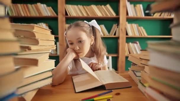 Menina caucasiana triste na biblioteca que tem algumas dificuldades durante o dever de casa do livro. Mulher perturbada precisa de ajuda ou conselhos enquanto estuda em casa. — Vídeo de Stock