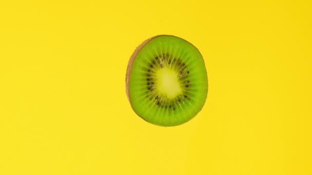 Kiwi切片在黄色背景上旋转前视镜 宏观食品 循环旋转 健康饮食的概念 有机食品 健康食品 生物食品 绿果特写 — 图库视频影像