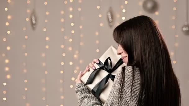 Gadis Cantik Berambut Cokelat Dengan Sweater Hangat Memeluk Kotak Hadiah — Stok Video
