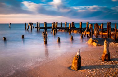 Long exposure at sunset of pier pilings in the Delaware Bay at S clipart