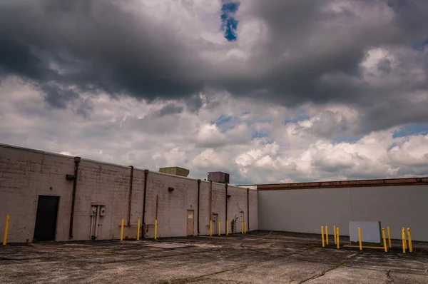 Clouds over the back of an abandoned shopping center. — Stock Photo, Image