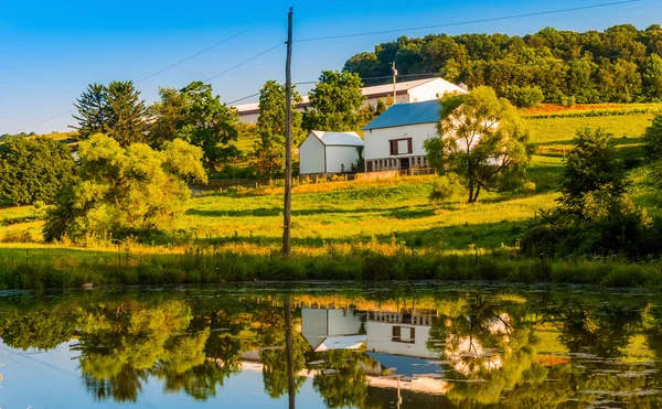 Barn and trees reflecting in a small pond on a farm in rural Yor — Stock Photo, Image